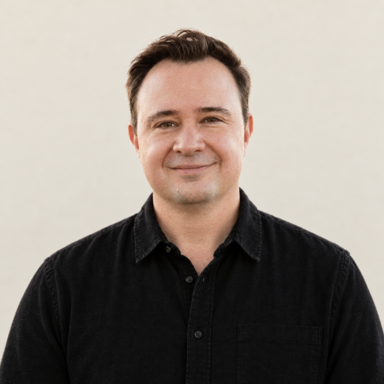 Tommy Magee in a black shirt against a light studio background
